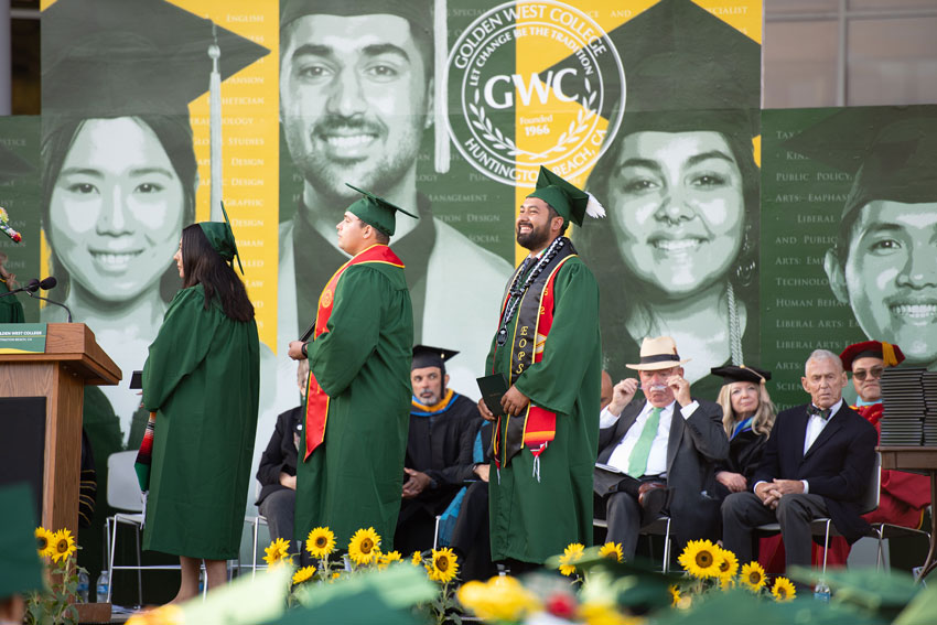 EOPS students walking across stage at graduation to receive their diplomas 