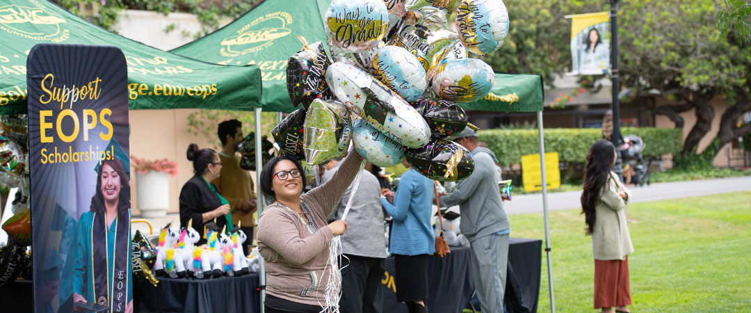 EOPS Student holding balloons at graduation